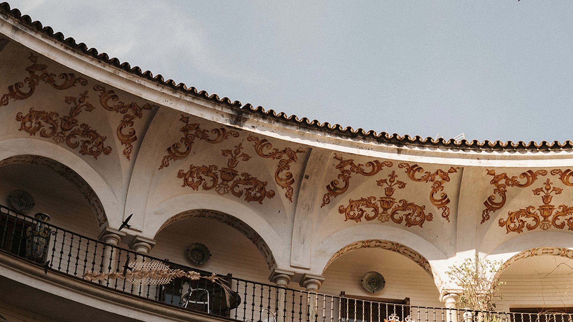 Patio sevillano con arquerías y balcones, espacio donde acontece la música